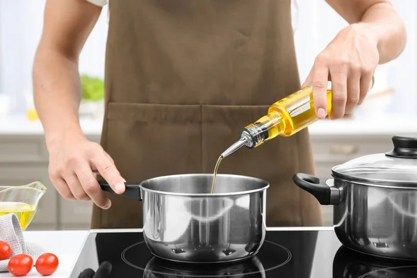 Hombre vertiendo aceite de cocina de la botella — Foto de Stock