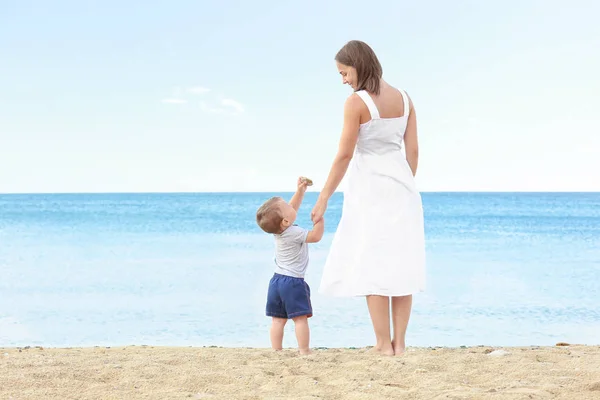 Glückliche Mutter mit kleinem Sohn am Strand — Stockfoto