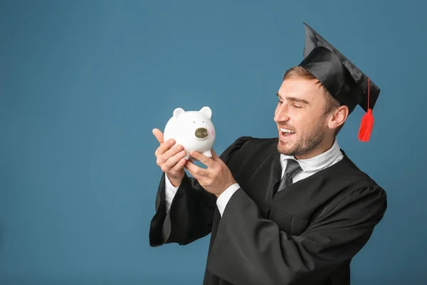 Young graduate with piggy bank — Stock Photo, Image