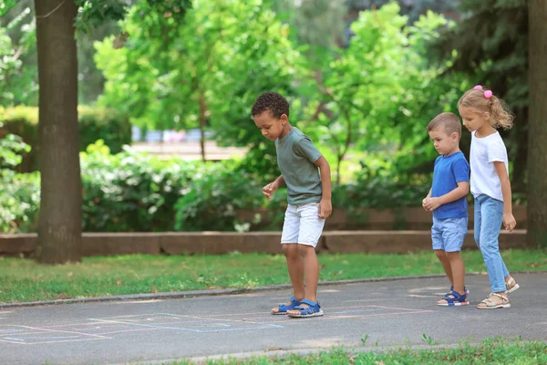 Niños pequeños jugando a la azadilla, al aire libre —  Fotos de Stock