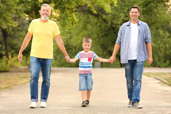 Kleiner Junge mit Papa und Opa spazieren im Park — Stockfoto