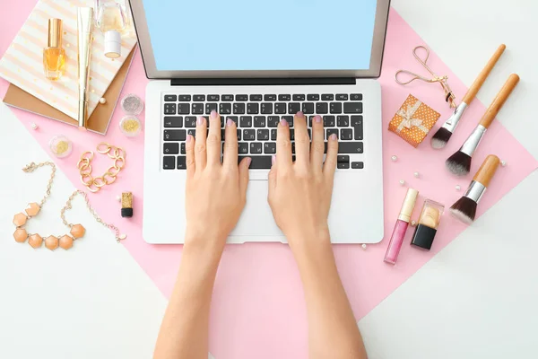 Mani di bellezza blogger con computer portatile e cose diverse sul tavolo — Foto Stock