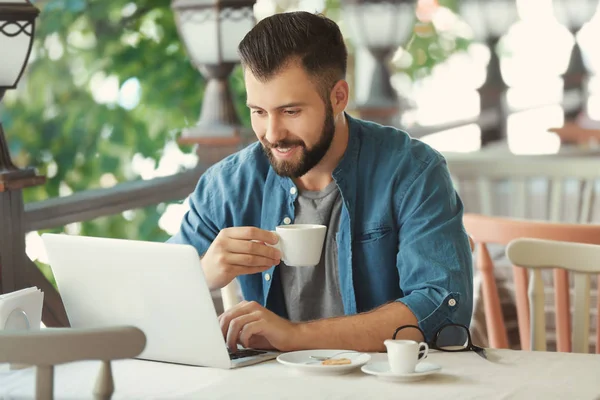 Μικρά blogger πίνοντας τον καφέ και να χρησιμοποιούν φορητό υπολογιστή στο υπαίθρια καφετέρια — Φωτογραφία Αρχείου