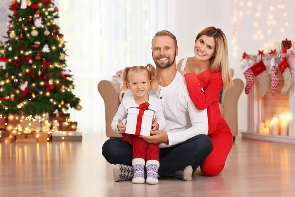 Lyckliga par med dotter och julklapp hemma — Stockfoto