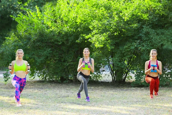 Young sporty women with dumb-bells doing exercise outdoor — Stock Photo, Image