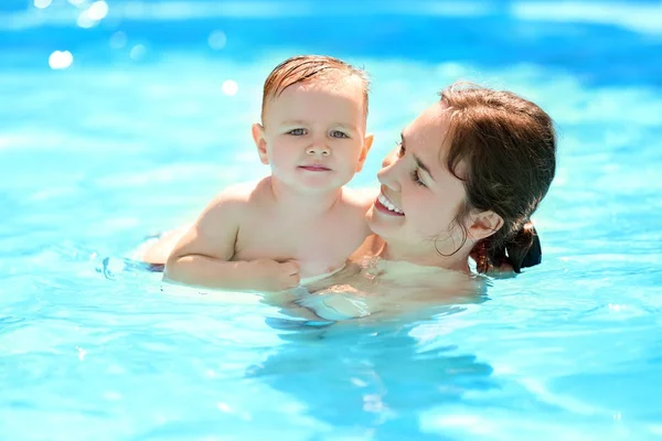Child swimming lesson. Cute little boy learning to swim with mother in pool Stock Photo