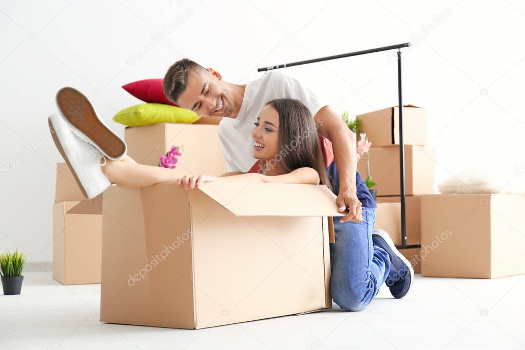 Young happy couple having fun while packing in room