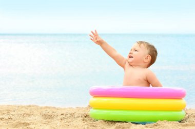 Sahilde küçük şişme havuzda şirin bebek