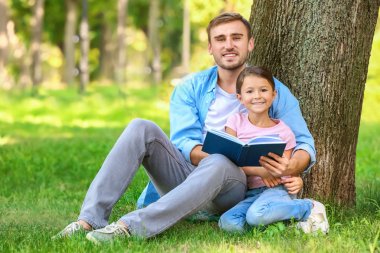 Genç adam ve onun küçük kızı okuma kitabı Park