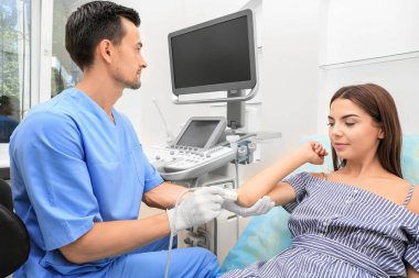 Hastanın dirsek iletken ultrason muayenesi kliniğinde doktor