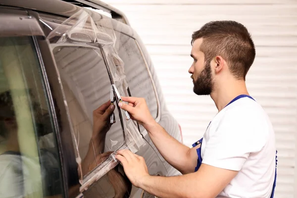 Arbeiter beschmiert Autoscheibe in Geschäft — Stockfoto