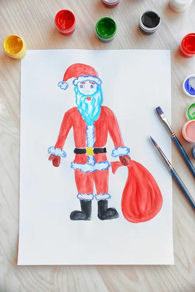 Kindermalerei von Weihnachtsmann mit Tasche auf dem Tisch — Stockfoto