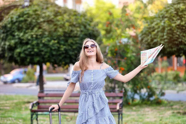 Schöne junge Touristin mit Karte im Park — Stockfoto