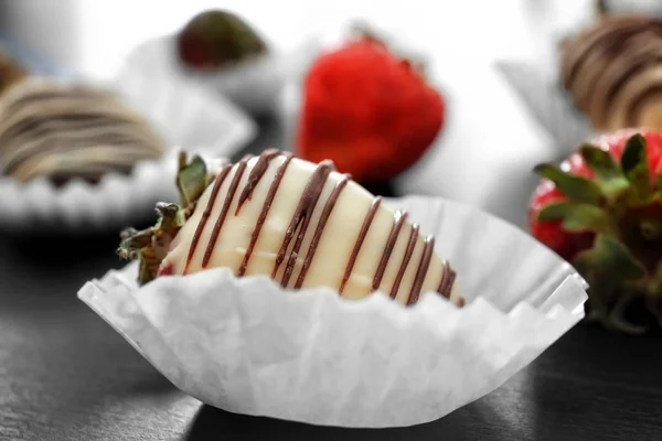 Sabroso chocolate sumergido fresa en la mesa oscura, primer plano —  Fotos de Stock
