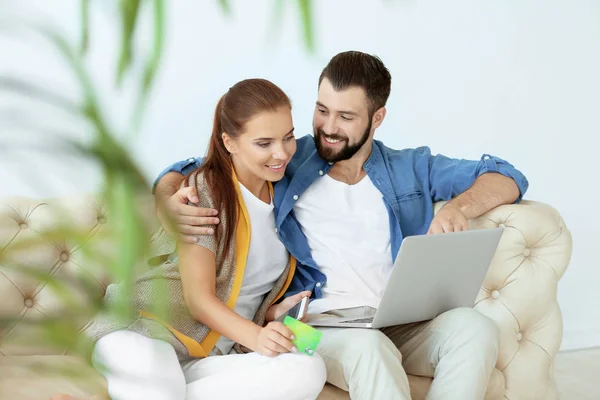 Casal jovem com laptop em casa. Conceito de compras na Internet — Fotografia de Stock