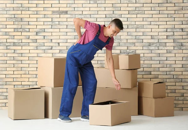 Homem sofrendo de dor nas costas enquanto se move caixas, dentro de casa — Fotografia de Stock