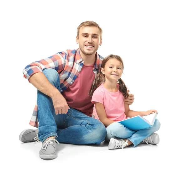 Ung man och hans lilla dotter läsa bok på vit bakgrund — Stockfoto