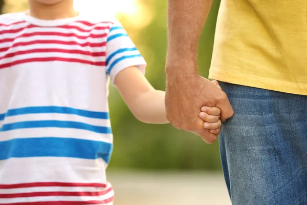 Niño sosteniendo la mano del abuelo al aire libre — Foto de Stock