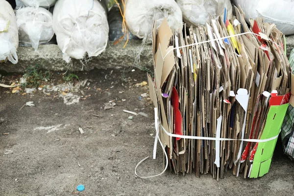 Papp lakan nära påsar med skräp utomhus — Stockfoto