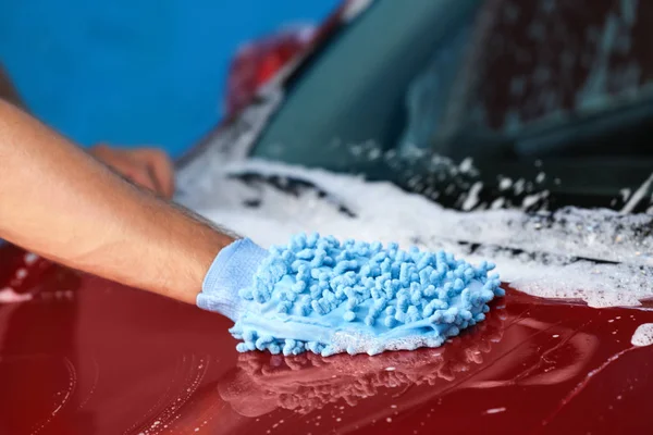 Hombre en la limpieza de automóviles con guante especial en el lavado de coches — Foto de Stock