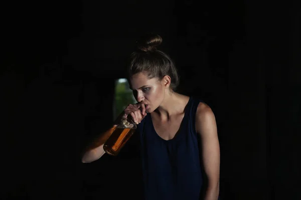 Mujer bebiendo alcohol en edificio abandonado — Foto de Stock