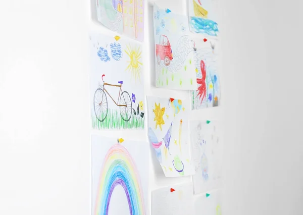 Different children's drawings on white wall — Stock Photo, Image