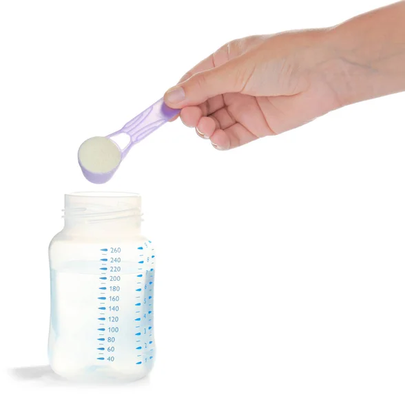Vrouw hand toevoegen melk formule aan water — Stockfoto