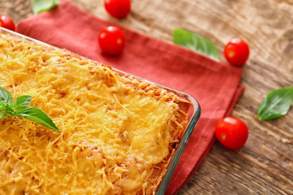 Skład z lasagne z mięsem i pomidorami na stole, zbliżenie — Zdjęcie stockowe