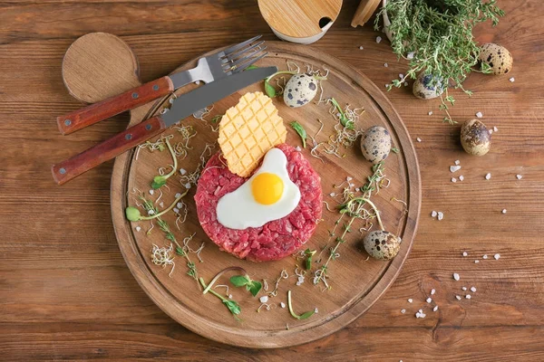 Delicioso bife tartare com ovo e wafer em tábua de madeira — Fotografia de Stock