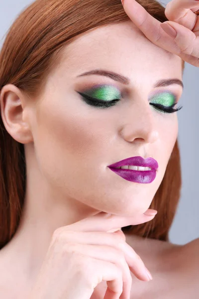 Hermosa mujer pelirroja con maquillaje verde brillante sobre fondo claro —  Fotos de Stock