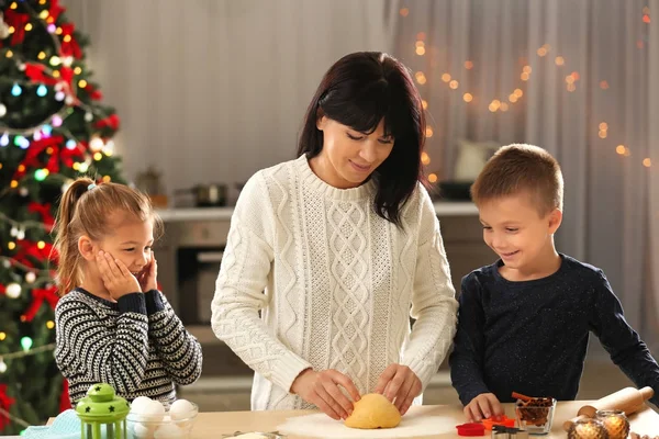 Moeder en kinderen maken van kerstkoekjes in keuken — Stockfoto