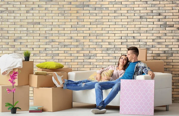 Jonge gelukkige paar op sofa in kamer nieuwe thuis — Stockfoto