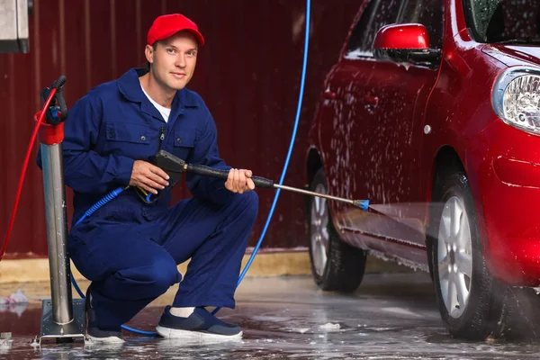 Man rengöring bil med högtrycksvatten vid biltvätt — Stockfoto