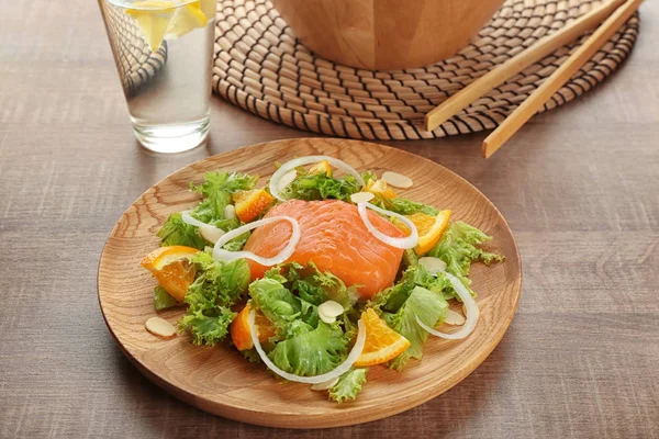 Prato de madeira com deliciosa salada de salmão na mesa — Fotografia de Stock