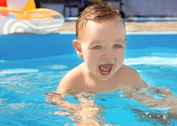 Çocuk yüzme dersi. Sevimli küçük çocuk babasıyla havuzunda yüzmeyi öğrenme