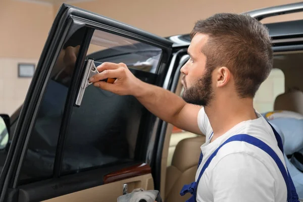 Obrero teñir la ventana del coche en la tienda — Foto de Stock