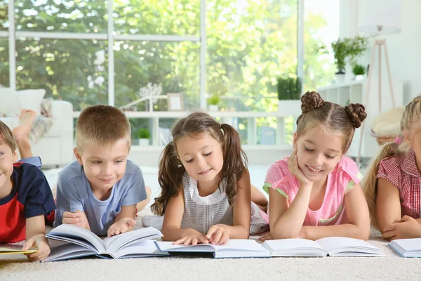 Bonito crianças lendo livros dentro de casa — Fotografia de Stock