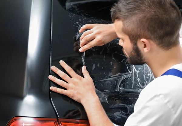 Arbeiter beschmiert Autoscheibe in Geschäft — Stockfoto