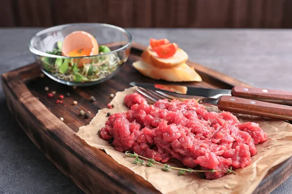 Délicieux tartare de steak sur planche de bois — Photo