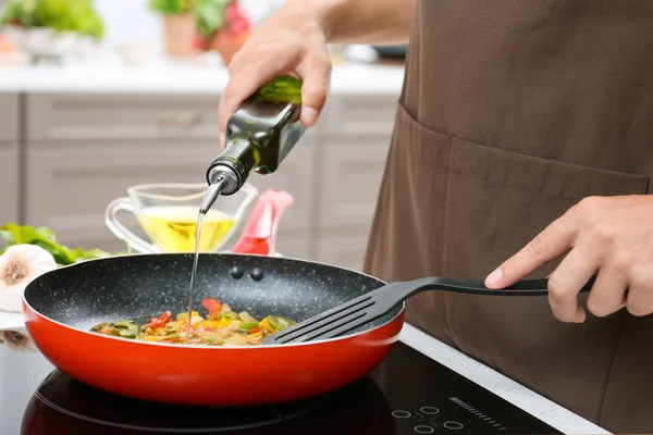 Homem derramando óleo de cozinha na frigideira — Fotografia de Stock