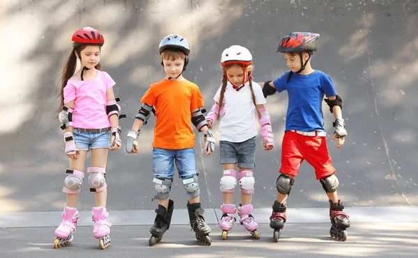 Söta barn på rullarna i skatepark — Stockfoto