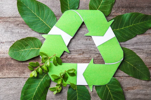 Composition avec symbole de recyclage et feuilles sur fond bois — Photo