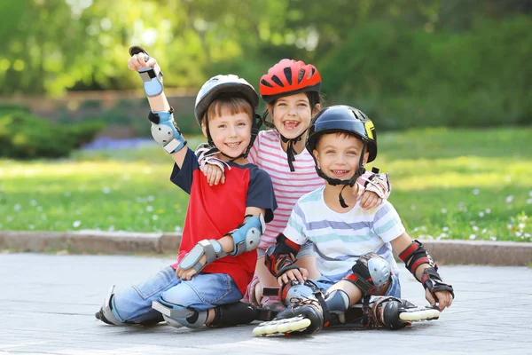 Cheerful children on roller skates in park — Stock Photo, Image