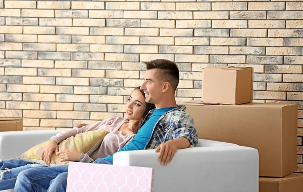 Jonge gelukkige paar op sofa in kamer nieuwe thuis — Stockfoto