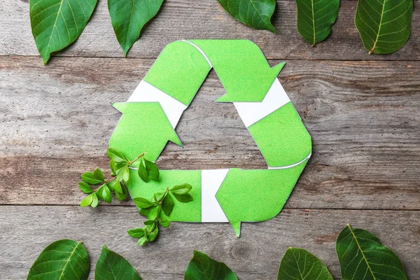 Composición con símbolo de reciclaje y hojas sobre fondo de madera — Foto de Stock