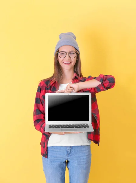 Teenager girl with laptop on color background — Stock Photo, Image