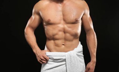 Kaslı adam havlu, koyu arka plan üzerinde sarılı