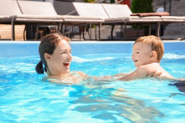 Çocuk yüzme dersi. Sevimli küçük çocuk öğrenme havuzu annesi ile yüzmek için