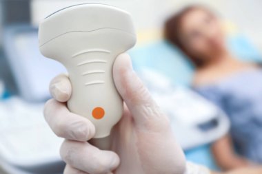 Holding arka plan üzerinde ultrason cihazları ve bulanık hasta doktor