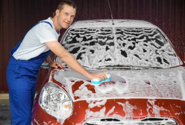 Otomobil araba yıkamacıda sünger ile temizlik adam